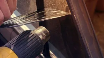 Taking off my old window tint with a heat gun in my garage